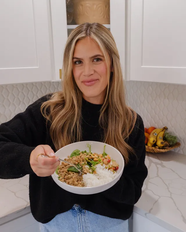 Daniela holding a prepared meal in her kitchen