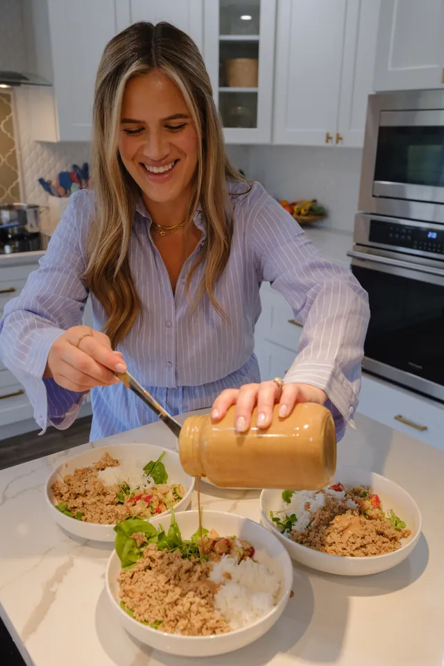 Daniela dressing three prepared bowls